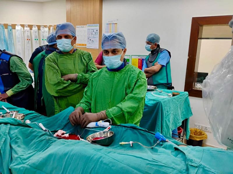 Cardiologist team performing a medical procedure in hospital.