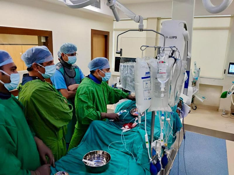 Medical team performing a cardiology procedure with advanced equipment.